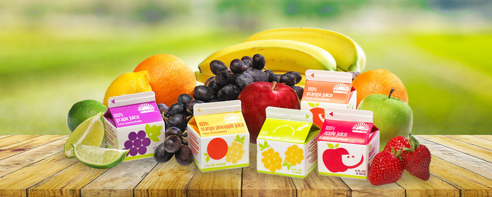 An array of fruit juice cartons with real fruit behind them
