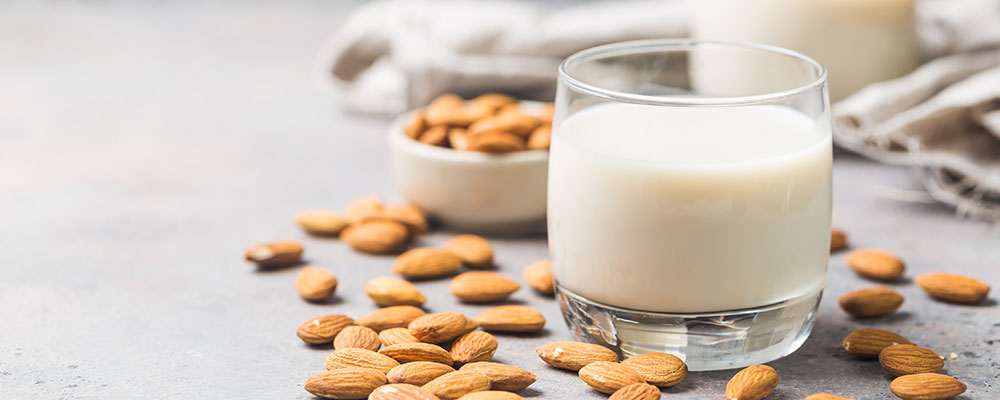 A glass of almond milk on a concrete surface