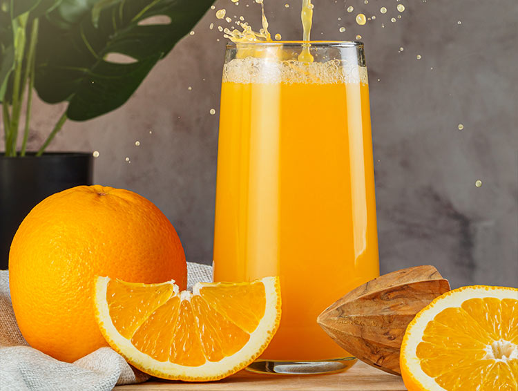 Cut oranges on a table with a glass of fresh orange juice