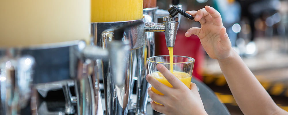 A child helping themselves to a glass of juice